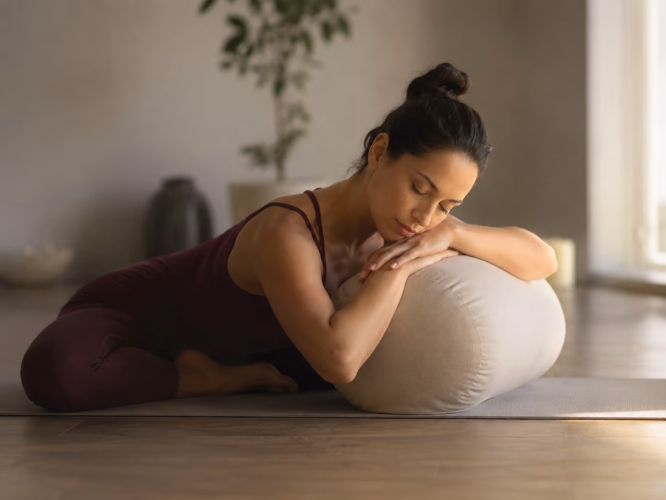 Woman moving through a gentle yoga pose in a peaceful space